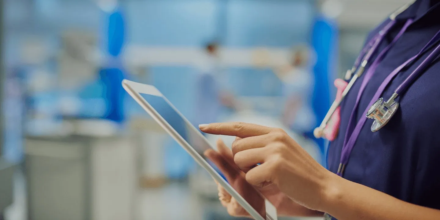 A clinician using a tablet in a hospital