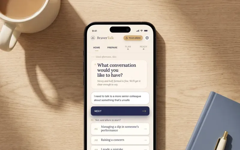 The BraverTalk app open on a phone on a wooden desk