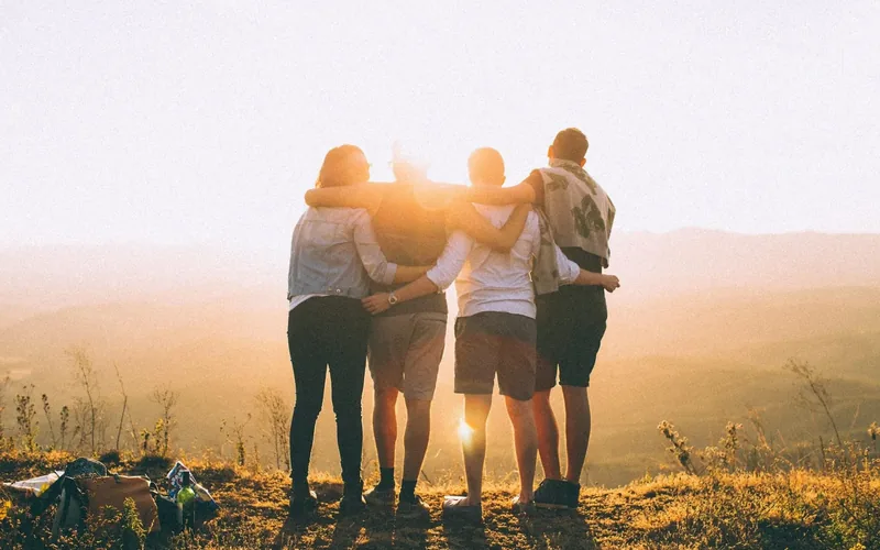 Colleagues standing together at sunset
